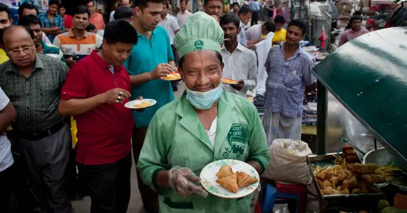 Zafar serves food from the food cart he was given by Concern in Nari Moitree, Paltan, Dhaka, Bangladesh.