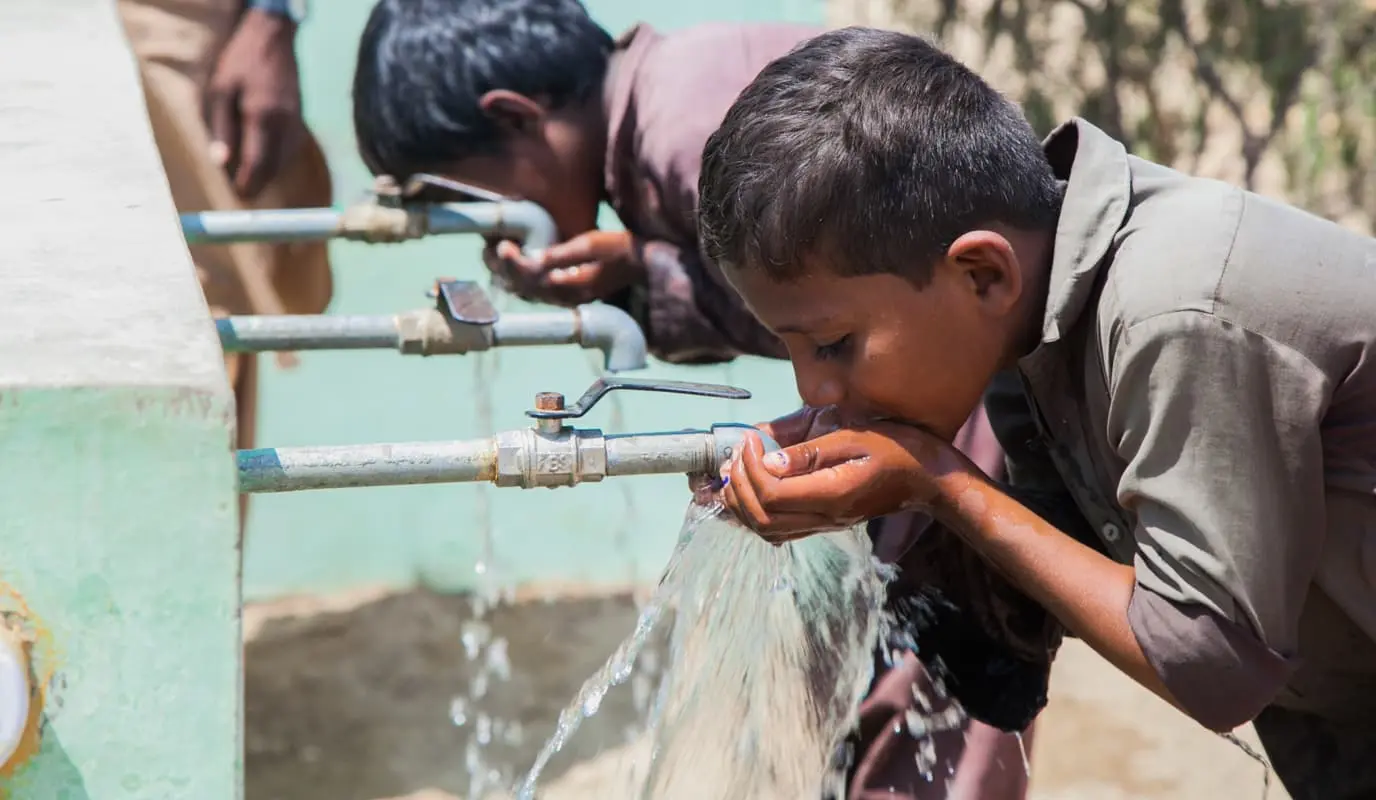 Children from Satla Bheel village, Pakistan, enjoy drinking water from the water plant system installed by Concern Worldwide