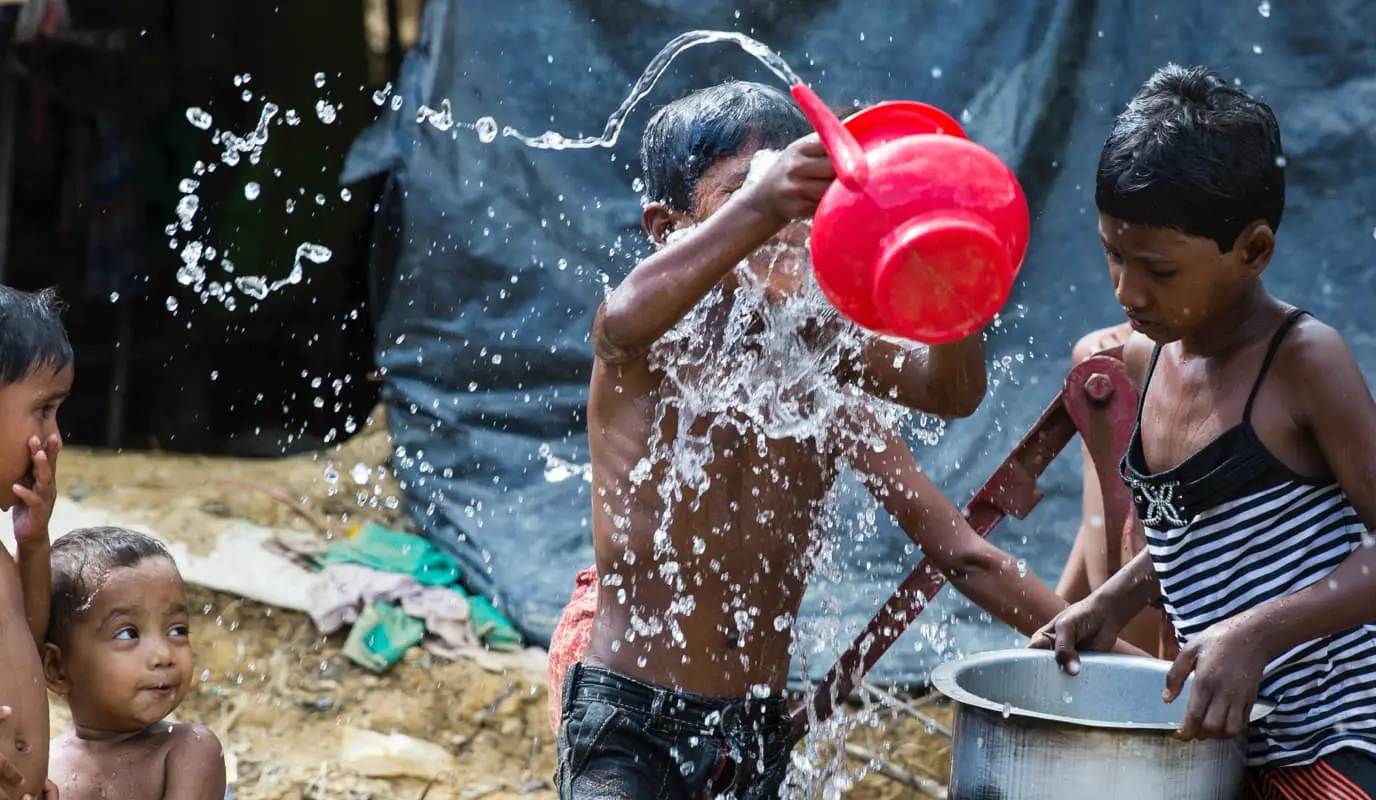 Kids wash in a Rohingya camp
