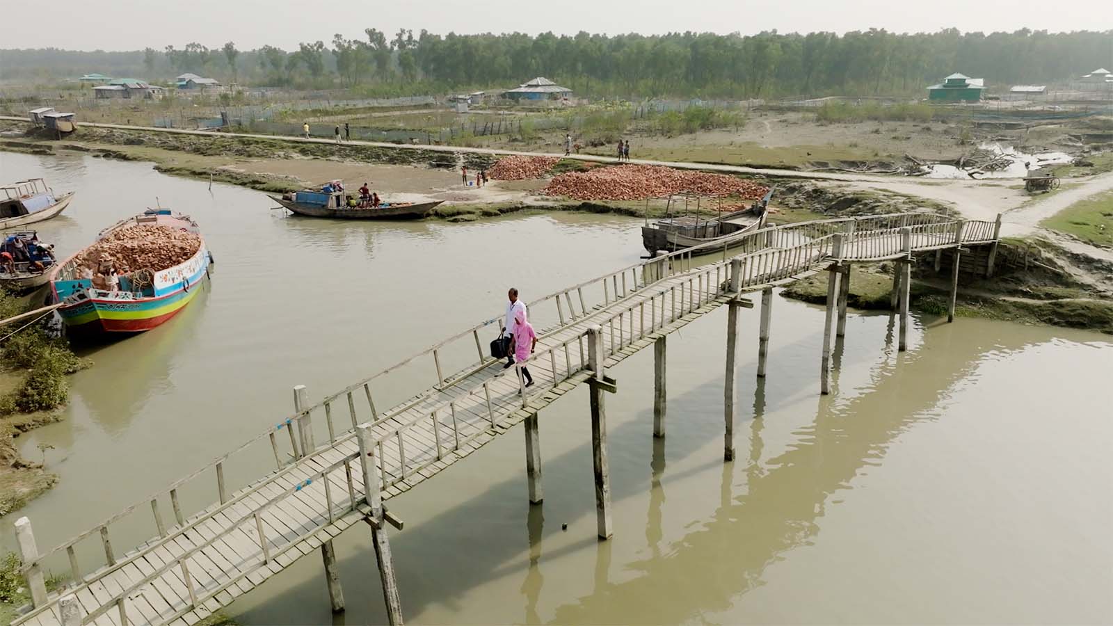 Midwife and doctor crossing a bridge in Bangladesh