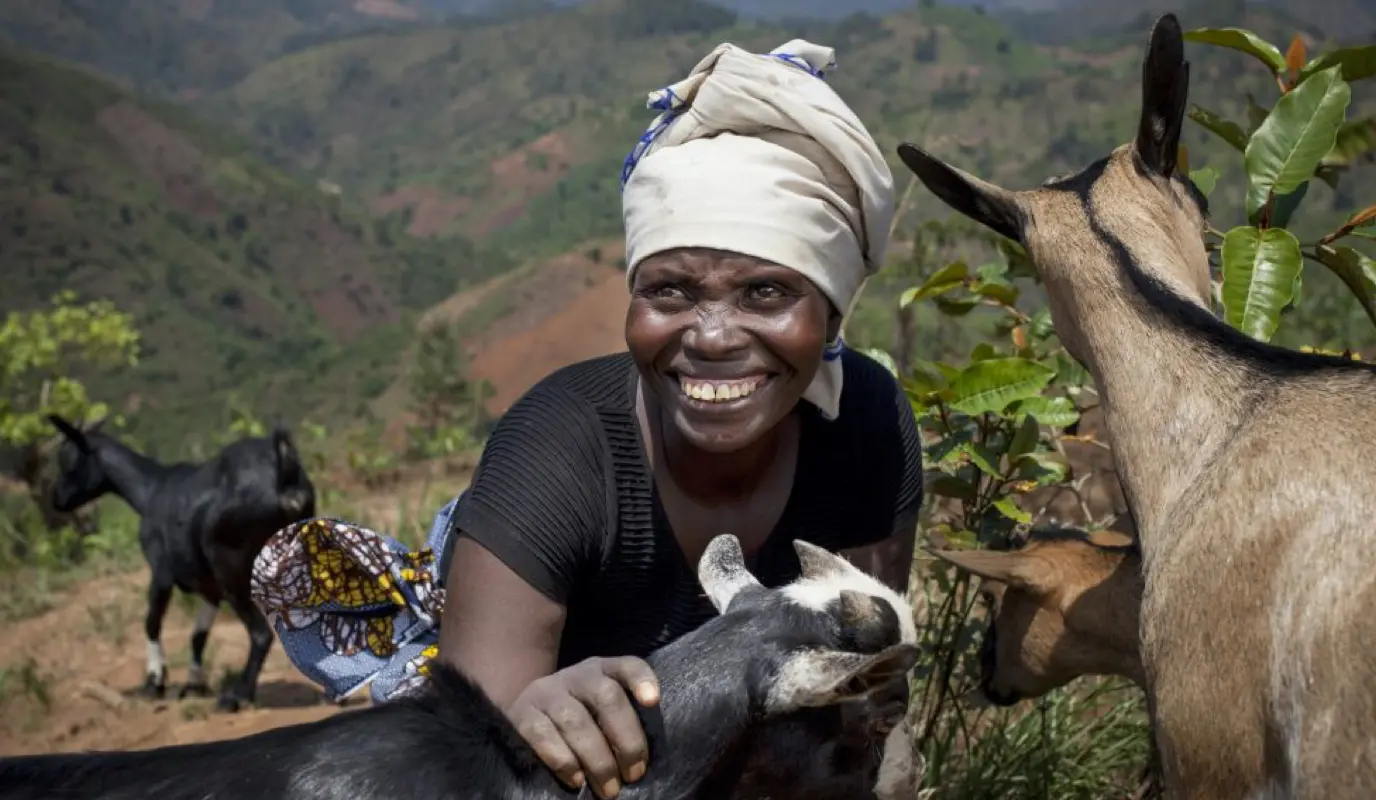 Female farmer in Burundi with goats.