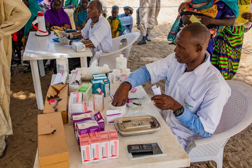 A Concern medical staff member filling a prescription at a mobile clinic in Chad.