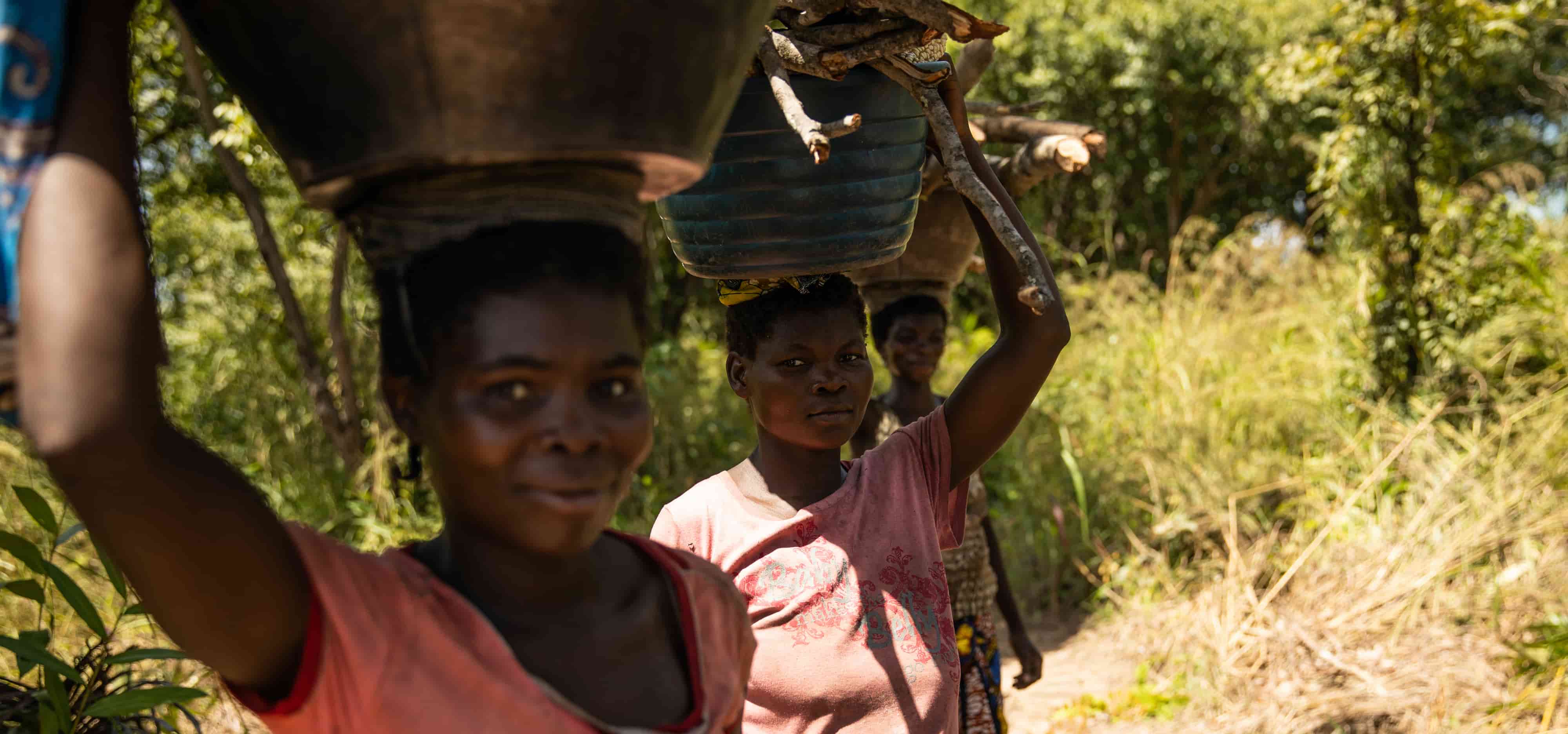Women carrying baskets of vegetables and firewood.