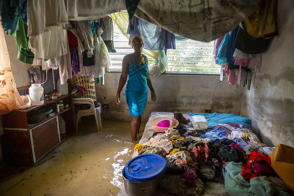 A woman in her flooded home in Haiti