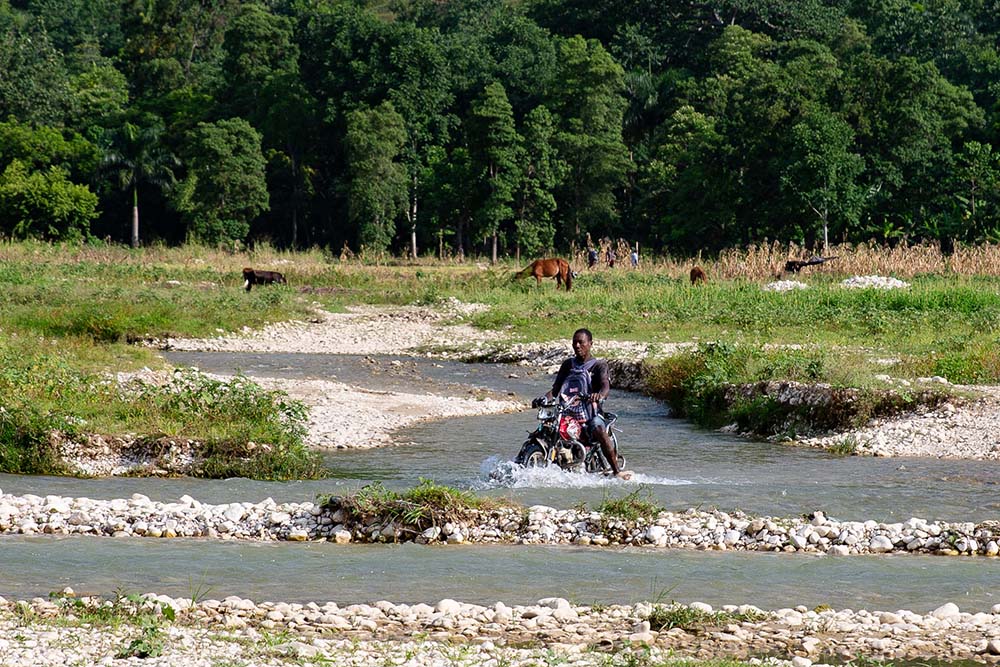 motorbike fording a river in haiti