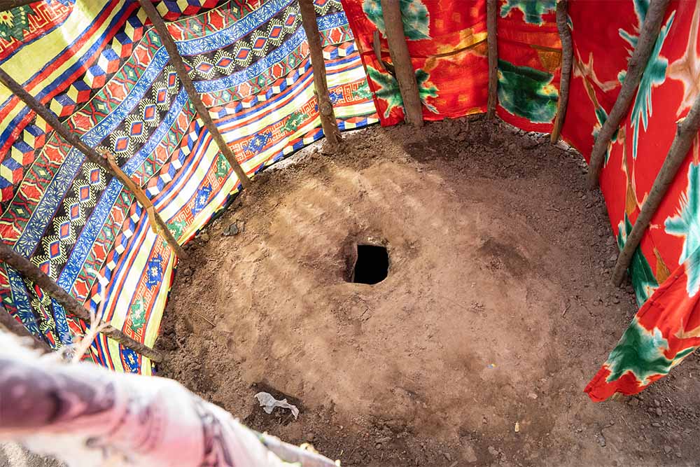 A basic pit latrine in Kenya surrounded by fabric