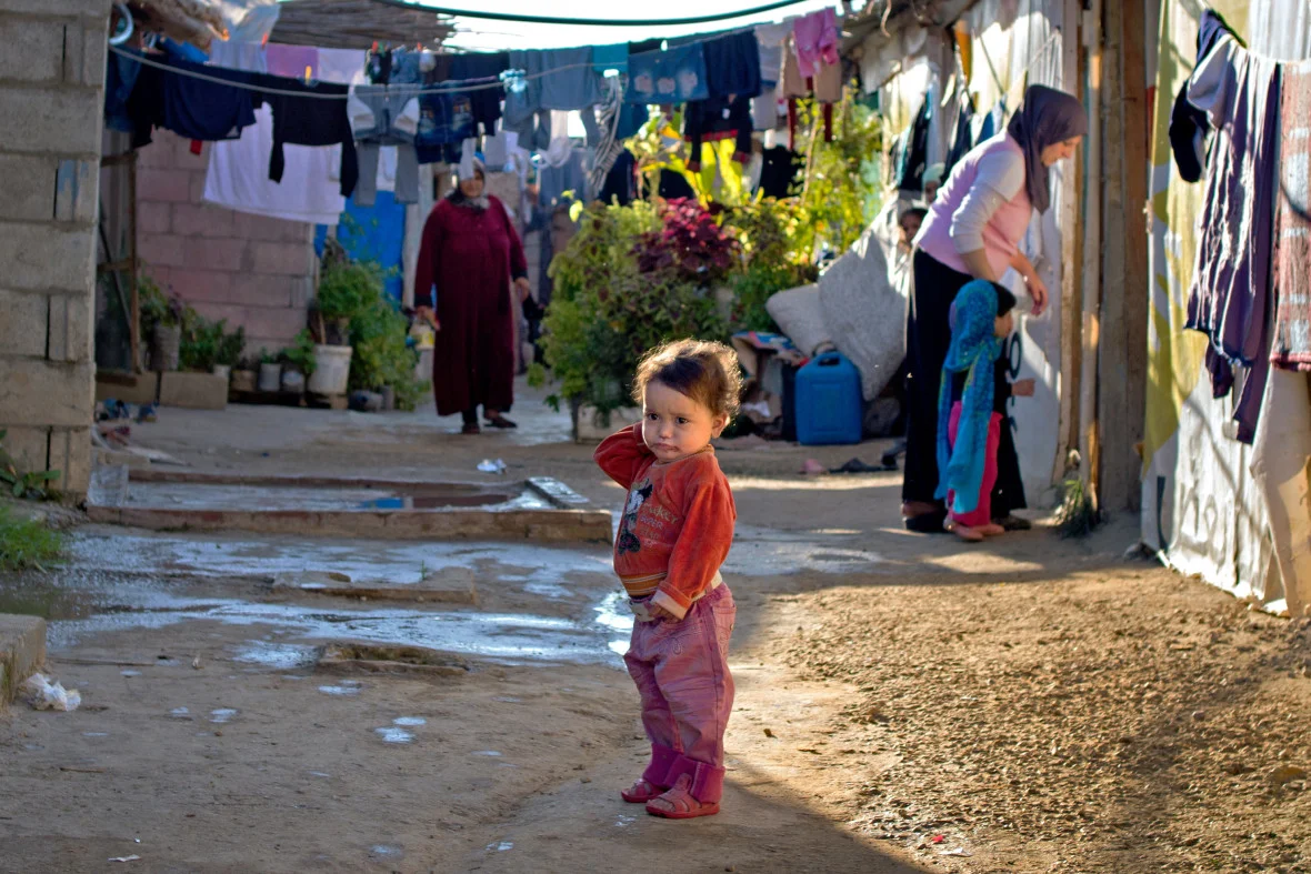 A Syrian child standing alone in an informal settlement