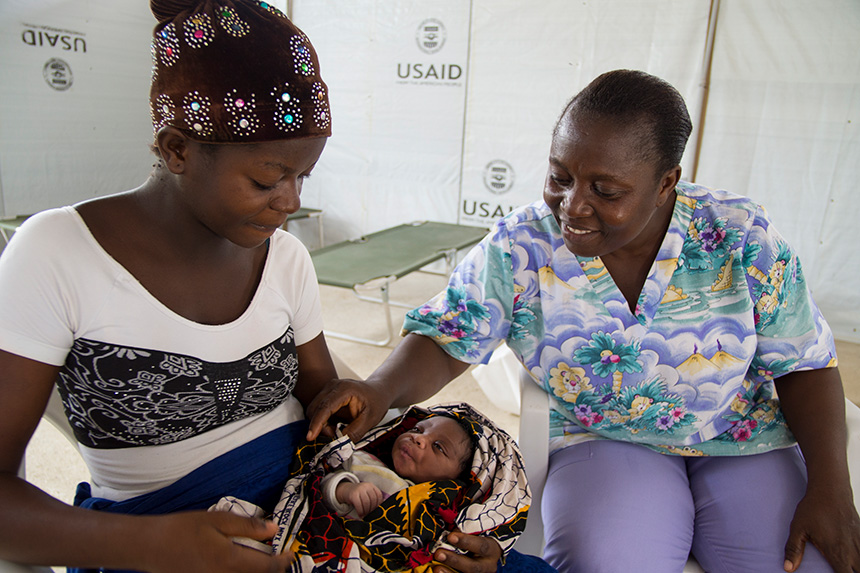 A midwife with a newborn baby and its mother in Liberia