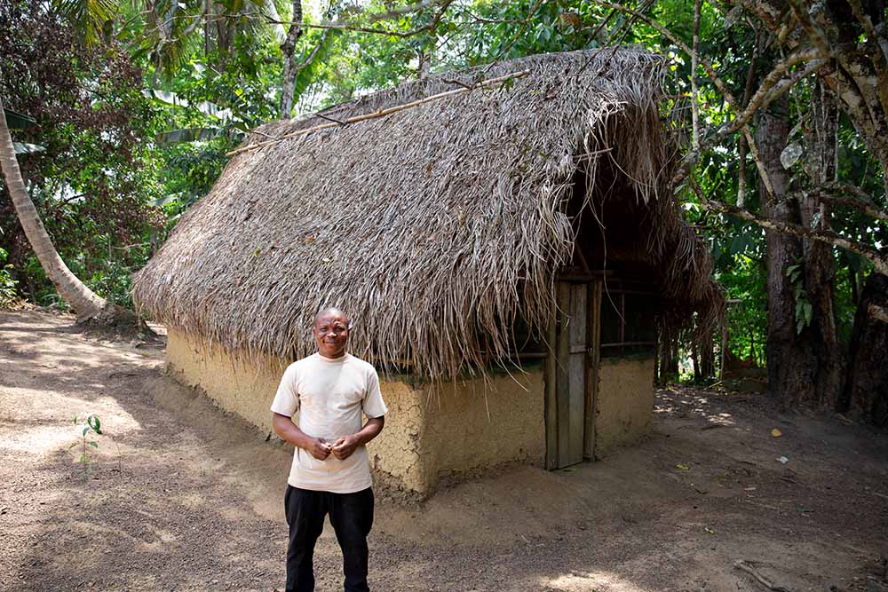 Man standing outside a snail house in Liberia