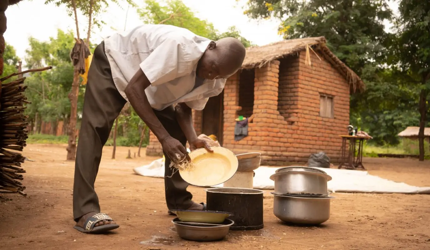 Forty Sakha helps his wife with the dishes and other household chores in Nsanje, Malawi.