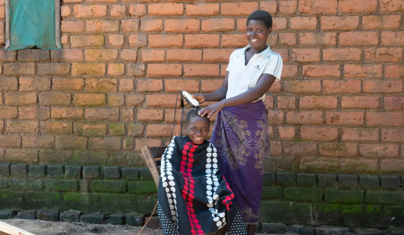 Anes James gives her son, Chabuka a haircut.
