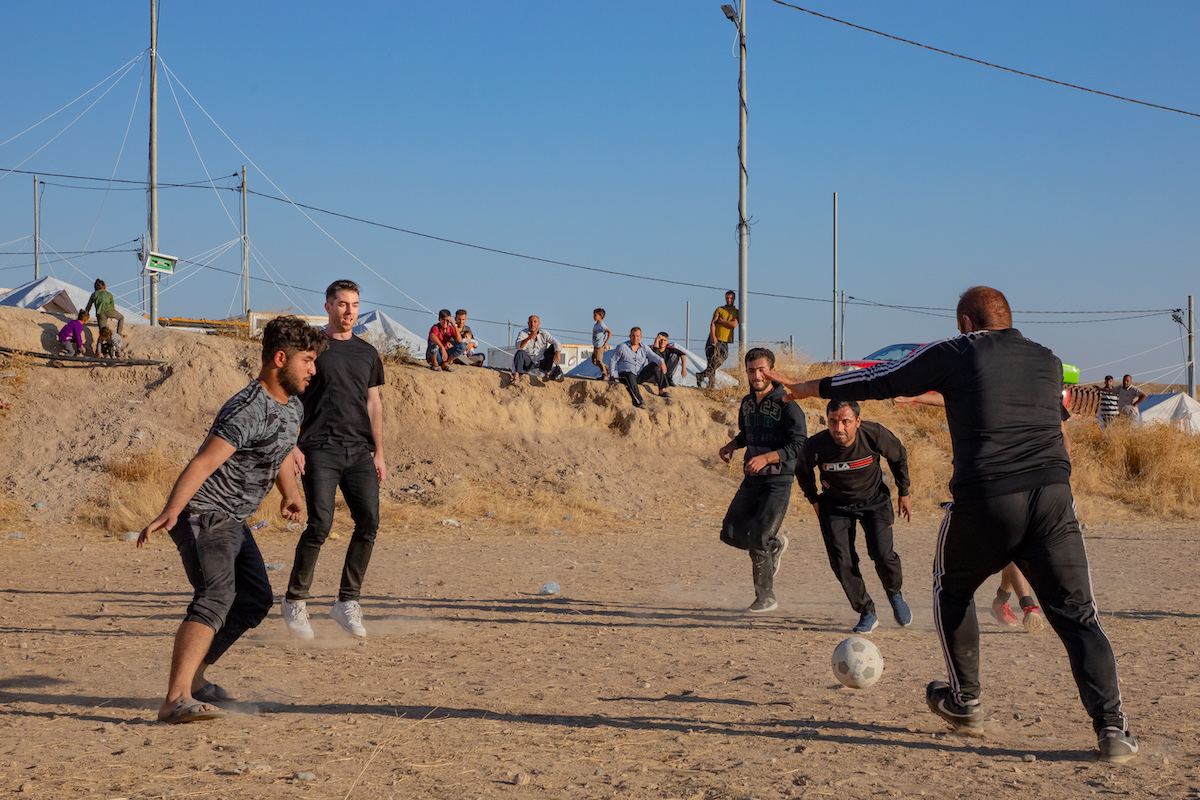 Gaelic soccer player and Concern Ambassador Michael Darragh MacAuley joins in on a game with residents of a displacement site in northwestern Iraq. (Photo: Gavin Douglas/Concern Worldwide)