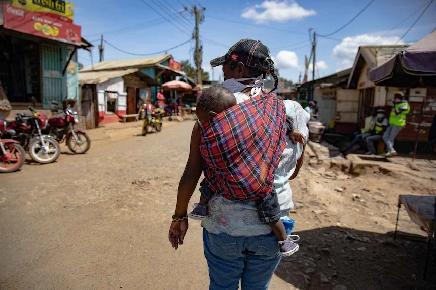 A kenyan mother and child walk through a slum in Nairobi