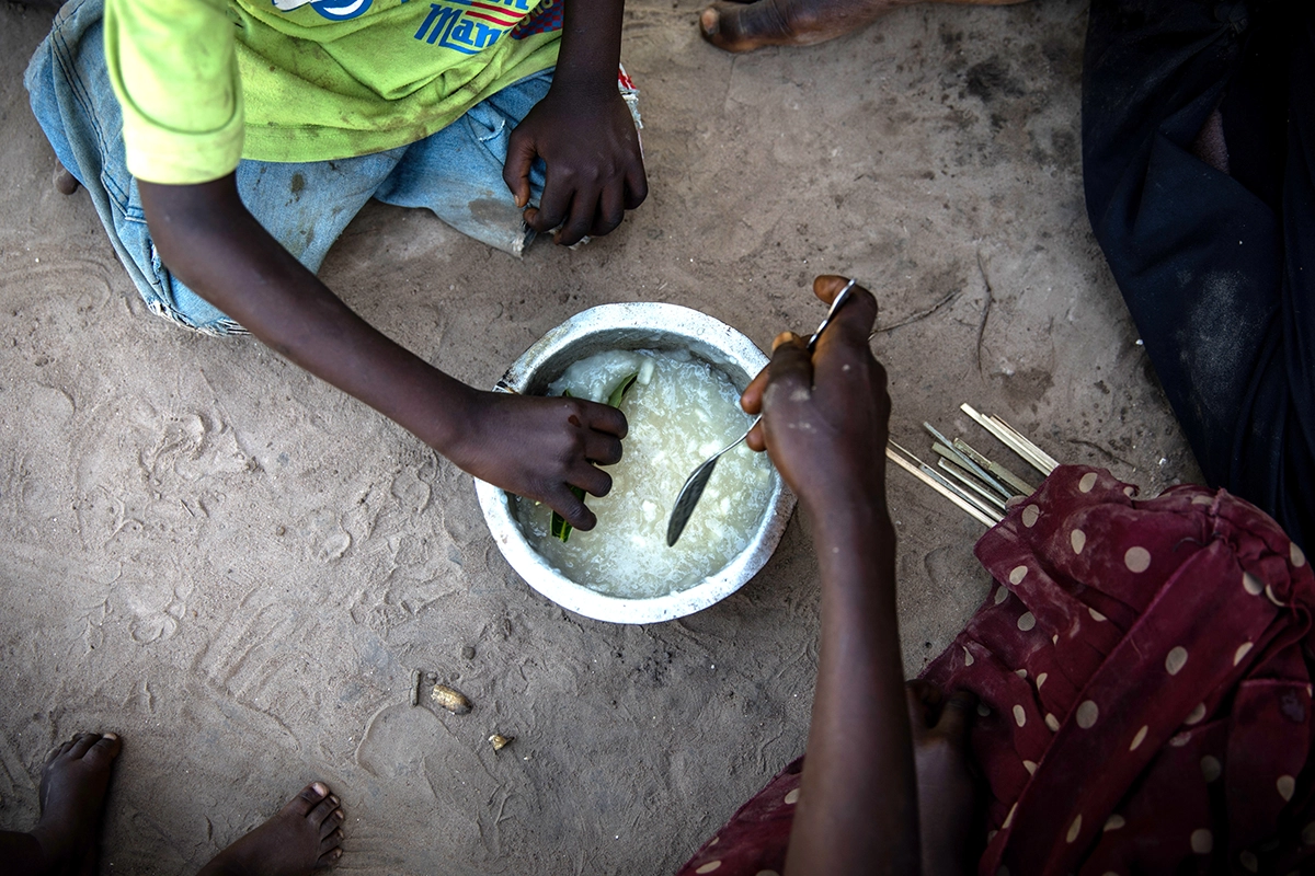 Eric Kyugu and his wife, Mado share breakfast with their children in the village of Pension, Manono Territory. (Photo: Hugh Kinsella Cunningham/Concern Worldwide)