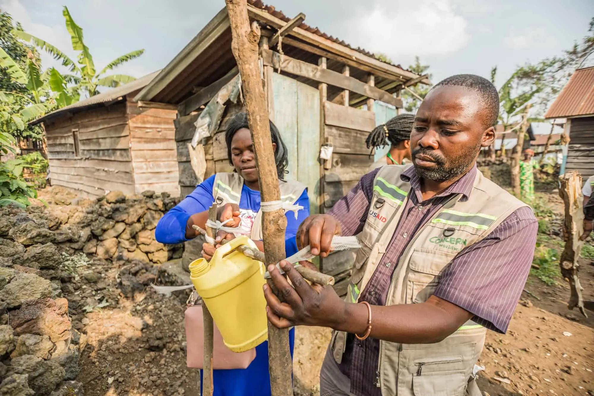 Concern Community workers Justin Mwihire Bulunga and Anita Kalamo help construct a hand washing station