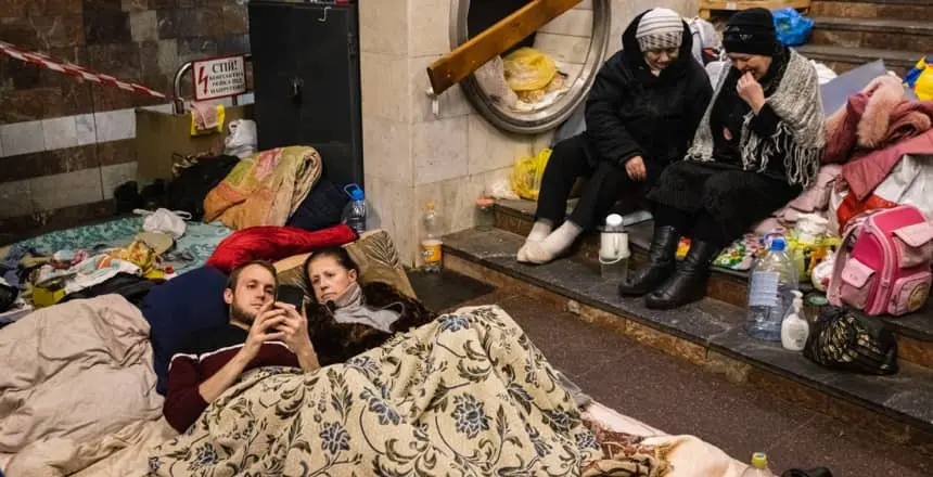 People look at their phones in Heroiv Pratsi metro station in North Eastern Kharkiv while taking shelter during an air raid