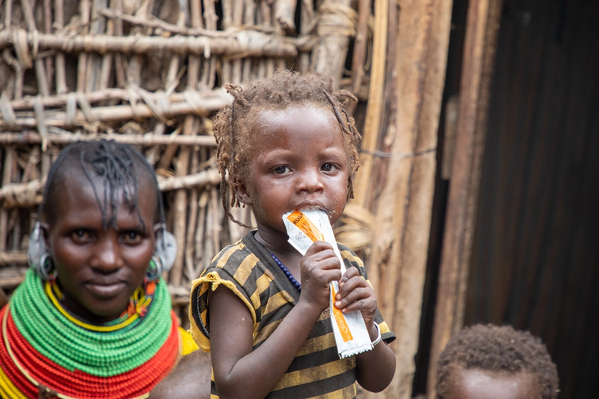 In Marsabit, Kenya, 19-month-old Midina eats a packet of RUTF to treat her severe acute malnutrition. (Photo: Gavin Douglas/Concern Worldwide)