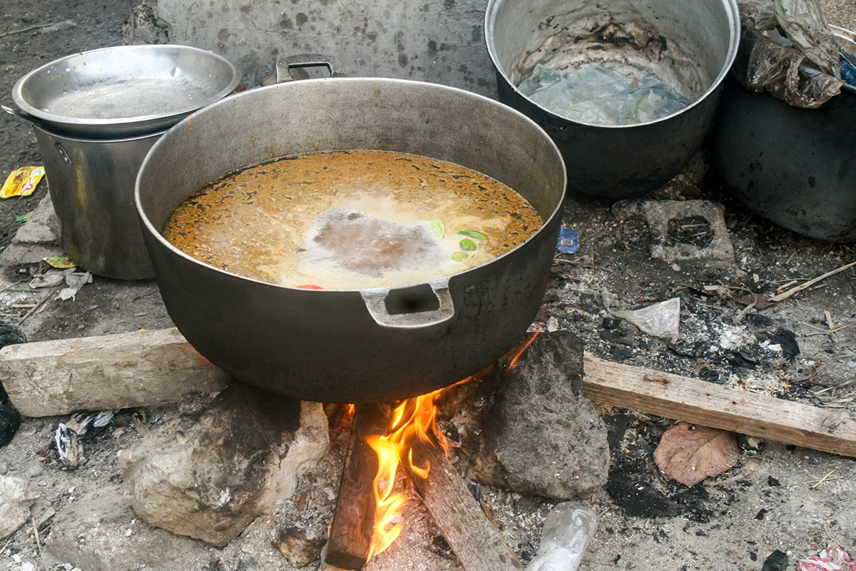 During the difficult weeks where Cité Soleil was on lockdown because of violence, each household had to be creative and find methods to cook food. This is a simple meal of rice and spices being prepared on some construction planks found close by. (Photo: Comité Consultatif de Jeunes/Concern Worldwide)