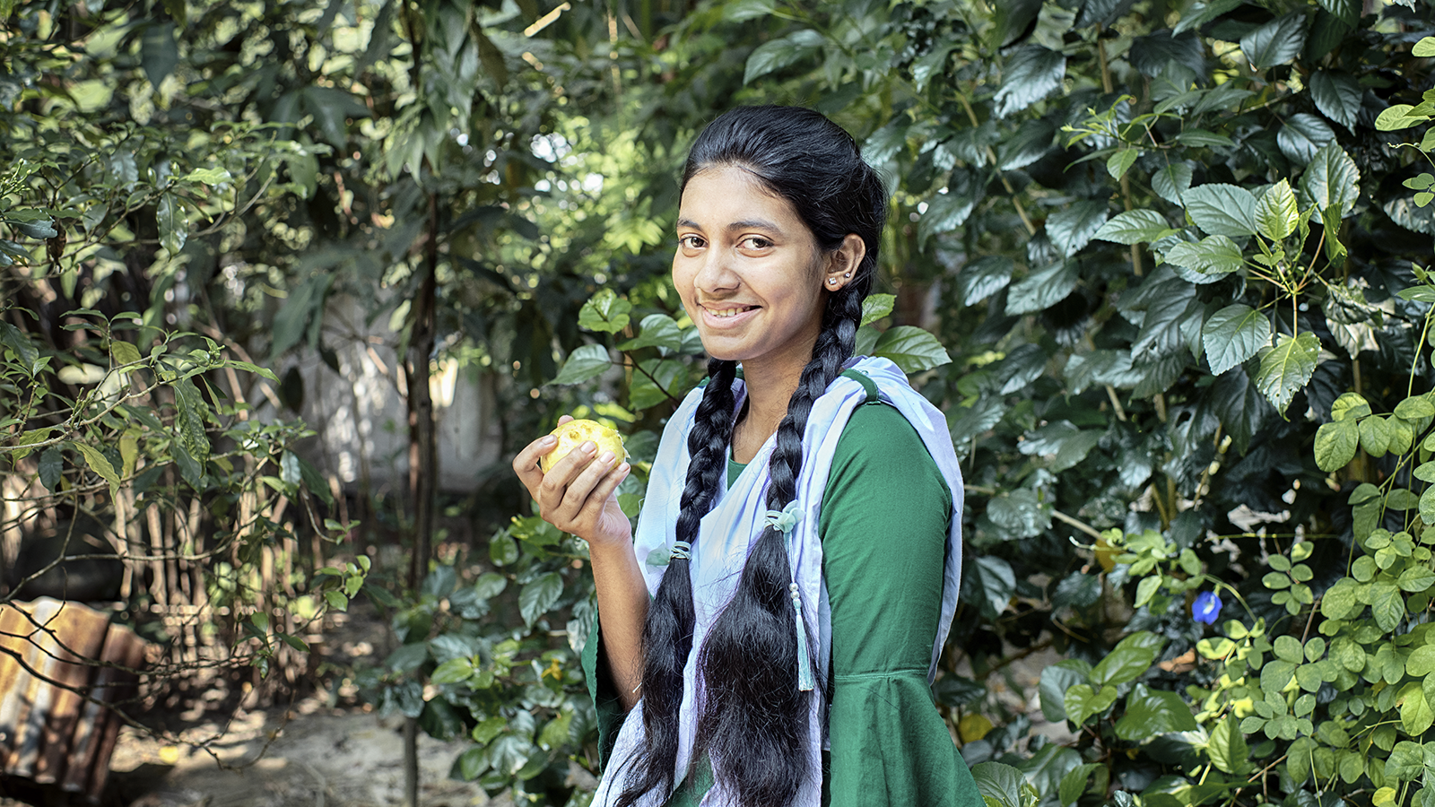 Fifteen year old Sharmin Akter is eating guava, which is a nutritious fruit. She often participates in group discussions in the yard meeting conducted by Concern Worldwide and its partner organizations to gain knowledge about healthy food, health and hygiene, gender, and social safety issues. The Collective Responsibility, Action, and Accountability for Improved Nutrition (CRAAIN) project have educated them to act right about nutrition and safeguarding health. (Photo: Mohammad Rakibul Hasan/Concern Worldwide)