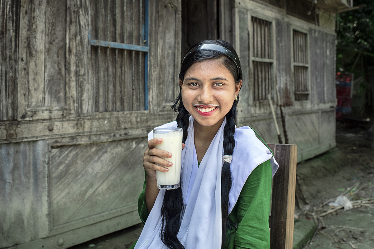 Fourteen year old Nazma Akter is drinking milk before leaving for school. The Collective Responsibility, Action, and Accountability for Improved Nutrition (CRAAIN) project has educated Nazma and many of her peers on the right to nutrition and safeguarding health. (Photo: Mohammad Rakibul Hasan/Concern Worldwide)