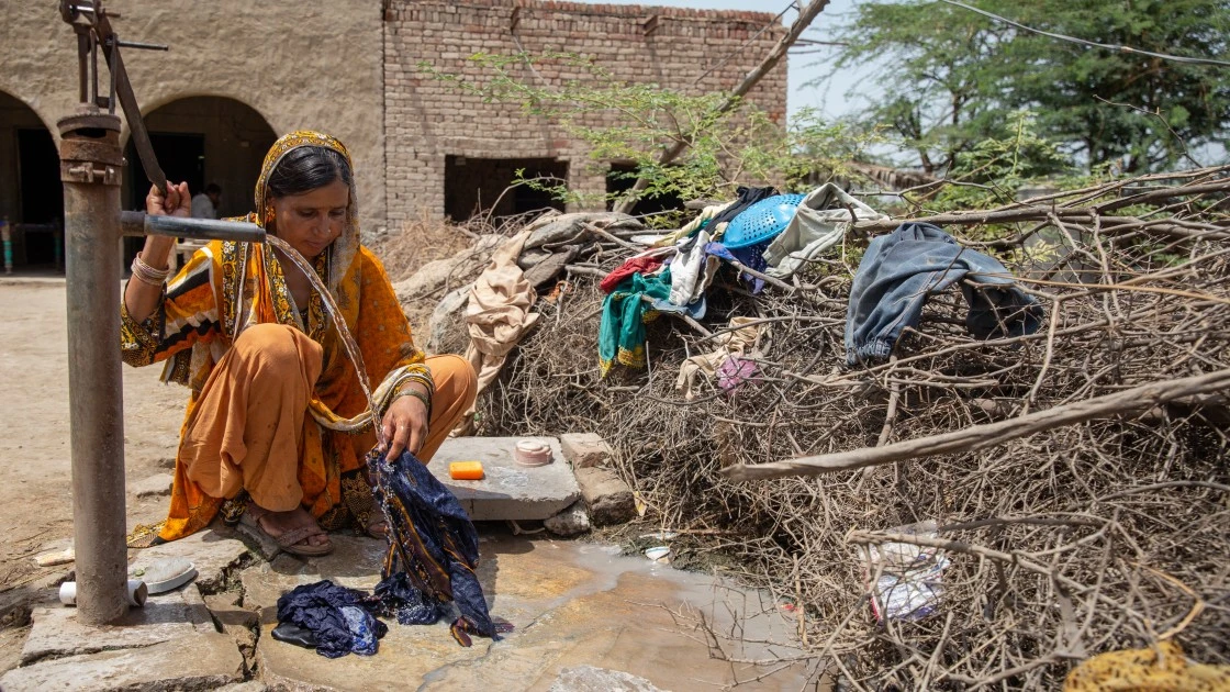 Nusrat washes her children's clothes outside their home in Sindh. (Photo: Zoral Khurram Naik/DEC/Concern Worldwide)