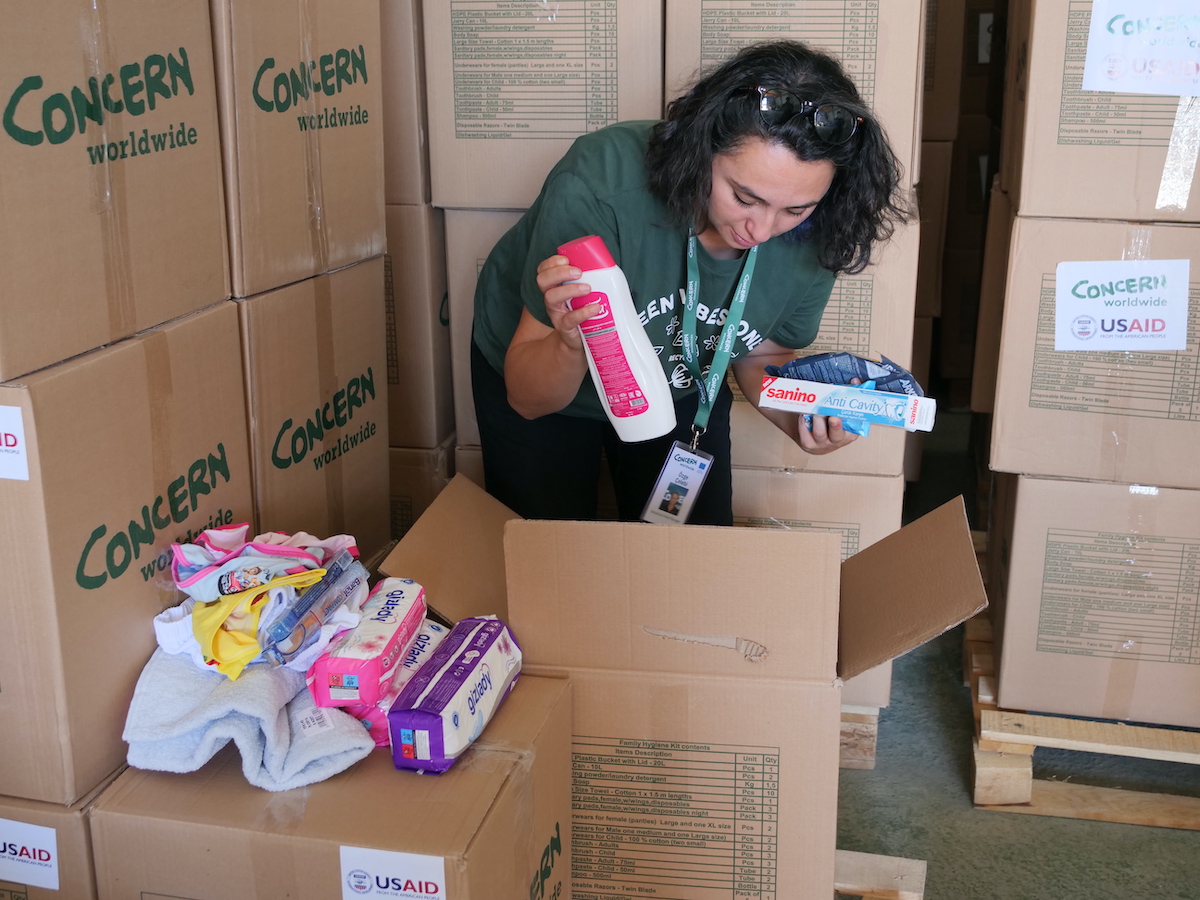 Ozge Celebi, Adiyaman Programmes Area Manager, checks the contents of a family hygiene kit at a Concern distribution at a warehouse in Adıyaman, Türkiye. (Photo: Eugene Ikua / Concern Worldwide)