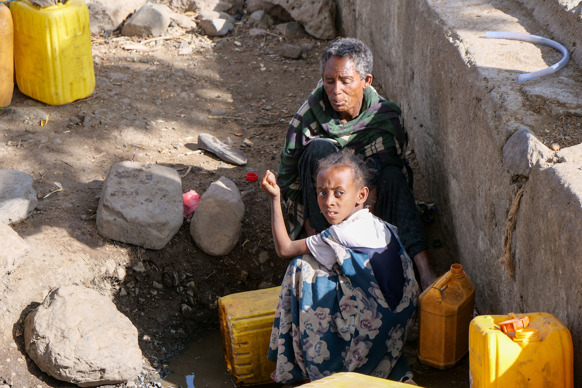 Adira Biru (50) and Meseret Adisu (12) collecting water in a nearby spring in Cherkos, East Belesa. Due to lack of alternative sources of water, the people in this community collect this water for drinking as well as for washing clothes. Their animals also use the same water for drinking. The spring has a very poor yield and it is the community hopes that with the watershed, the yield in the spring will improve. Photo: Eugene Ikua/Concern Worldwide.