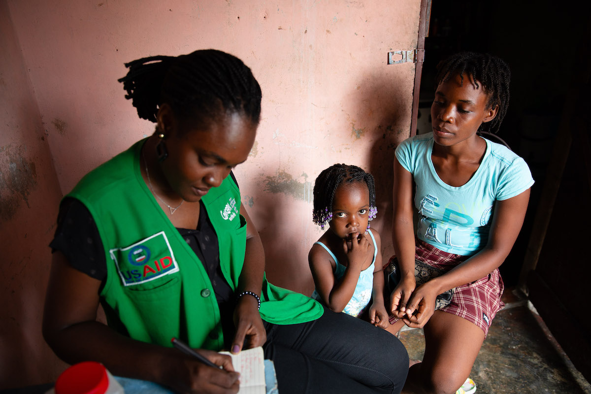 Michaelle Appolon of Concern Worldwide in Haiti interviews Felicie Jeune and her daughter Celise Jean Baptiste at their home in Cité Soleil, Port-au-Prince. The family participates in the USAID-funded Manje Pi Byen program. (Photo: Kieran McConville/Concern Worldwide)