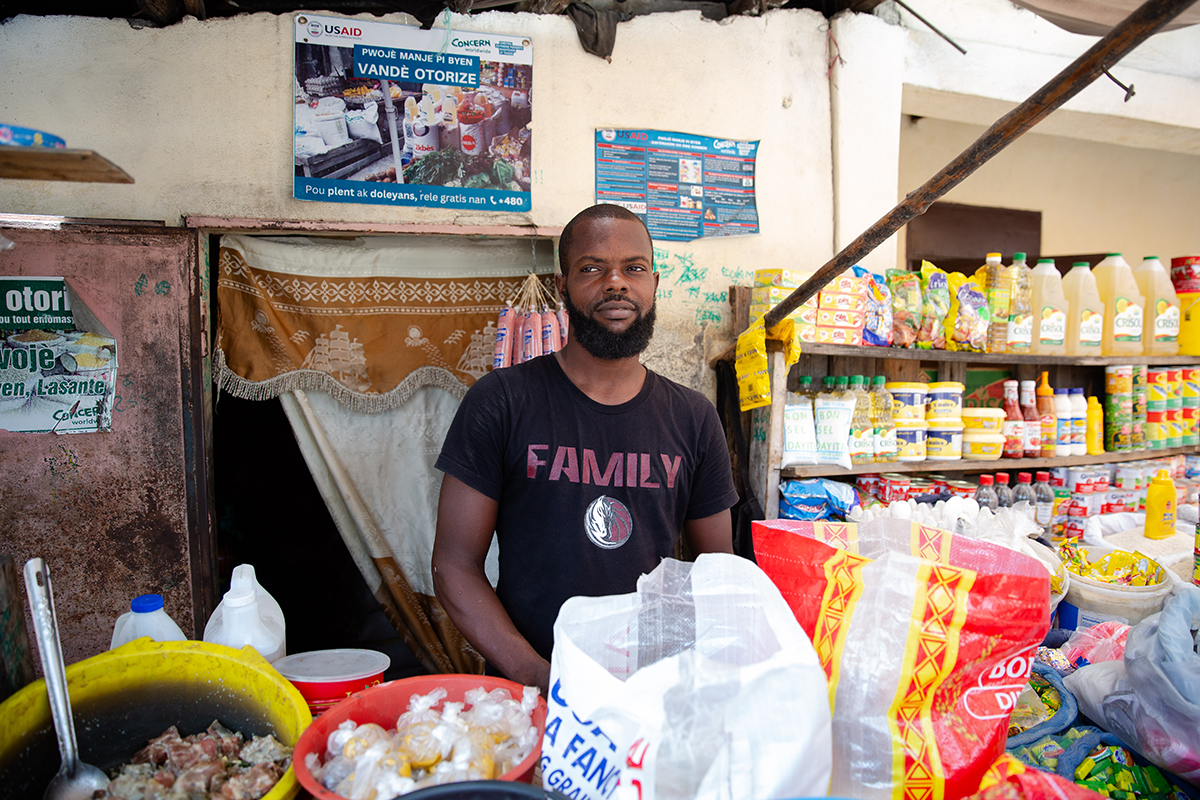 Quetal Joseph, a participating vendor in the USAID-funded Manje Pi Byen program, at his stall in a street market in Cité Soleil, Port-au-Prince, Haiti. (Photo: Kieran McConville/Concern Worldwide)