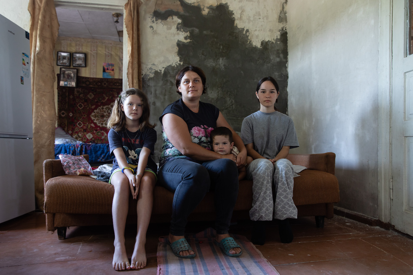 IDP Lesya* (33) with her three children in a house in Sumy Oblast where they were allowed to stay after the death of the owner. (Photo: Mykhaylo Palinchak/Concern Worldwide)