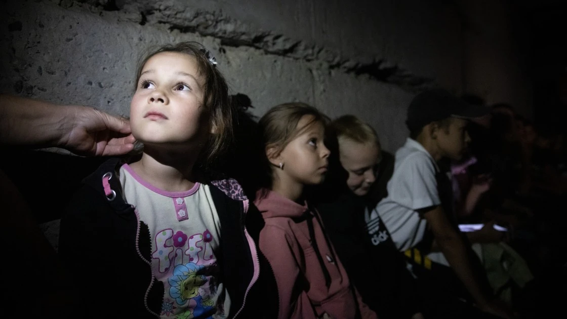 Ukrainian children wait in their school's bomb shelter for an air raid to end. Dark and damp, the basement still needs renovation. (Photo: Mykhaylo Palinchak / Concern Worldwide)