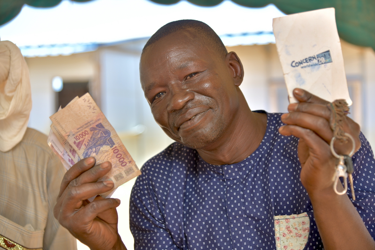 Programme participant Aboubacar Magagi presents his received cash and his distribution card during the cash distribution activity funded by ECHO as part of the lean season response project, Tahoua. (Photo: Concern Worldwide)