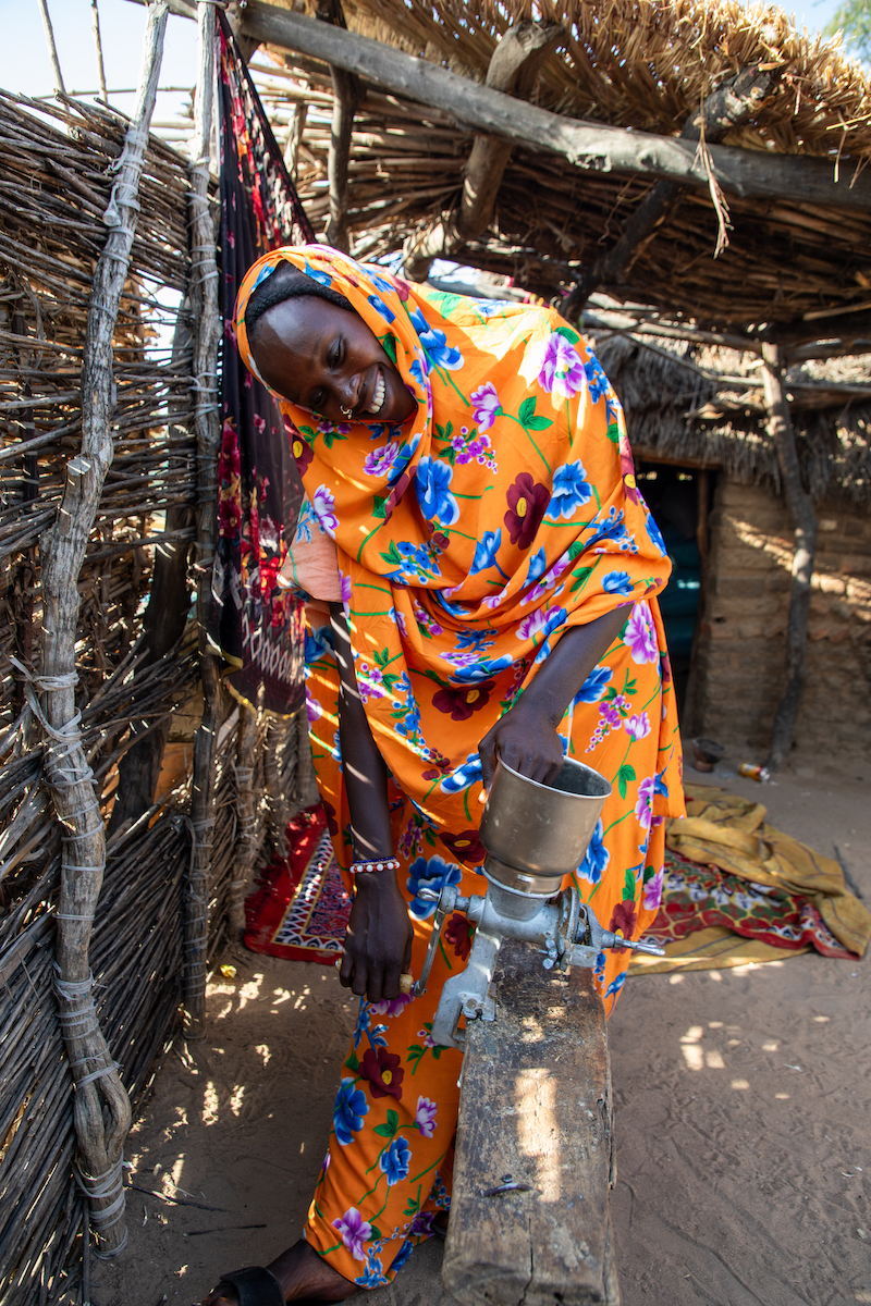 Mahadia Gamar has participated in Concern Chad's Green Graduation Program. Here, she shows off her improved harvests on her farm, and the peanut grinder she bought with Concern's support. She earns extra income grinding nuts for other women in her community. (Photos: Eugene Ikua/Concern Worldwide)