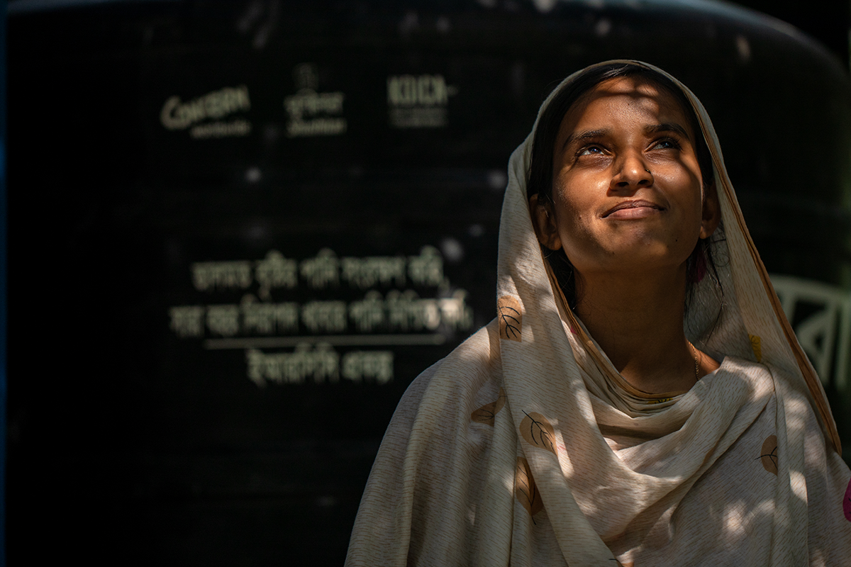 Halima in front of the water tank set in her yard in Kalabogi, Sutarkhali, Dacope. "This fills up during the rainy season. Since we are a large family, the reserved water can only serve us for the next 5-6 months. Then we have to buy drinking water, 8 to 10 liters every single day.” (Photo: Mumit M/Concern Worldwide)