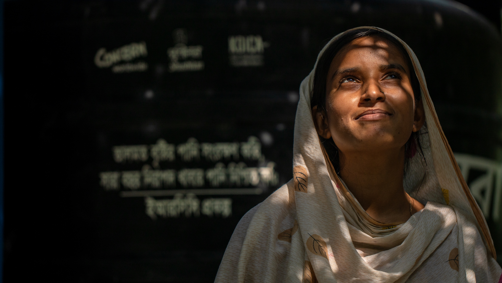 Halima in front of the water tank set in her yard in Kalabogi, Sutarkhali, Dacope. "This fills up during the rainy season. Since we are a large family, the reserved water can only serve us for the next 5-6 months. Then we have to buy drinking water, 8 to 10 liters every single day.” (Photo: Mumit M/Concern Worldwide)