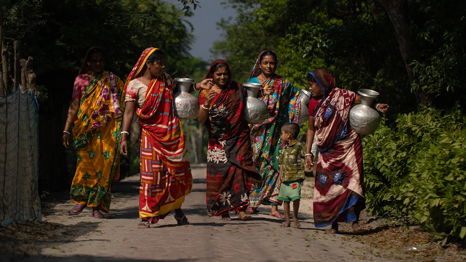 Every day it’s a 40-minute walk for this group of women to take drinking water to their homes from the only rainwater preserving tank that the community depends on, in Shakbaria, North Bedkashi, Koyra. (Photo: Mumit M/Concern Worldwide)