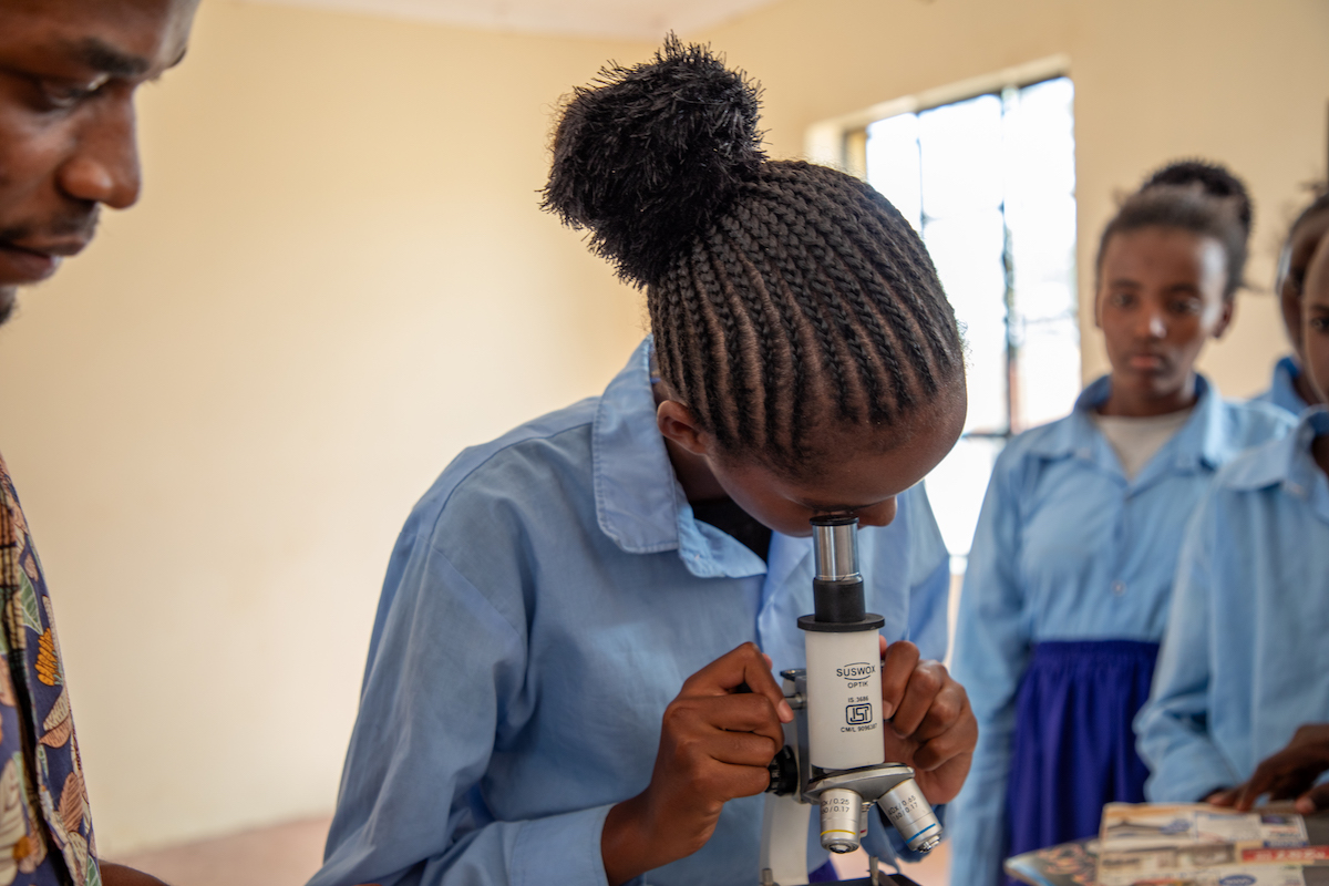 Bubisa Junior Secondary School student Midina Tura looks through a microscope. (Photo: Eugene Ikua/Concern Worldwide)