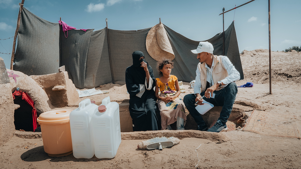 An internally-displaced mother with her child sit beside their underground/caved home (made by the family to protect from extreme weather conditions) in Al-Salam IDP site. (Photo: Ammar Khalaf/Concern Worldwide)