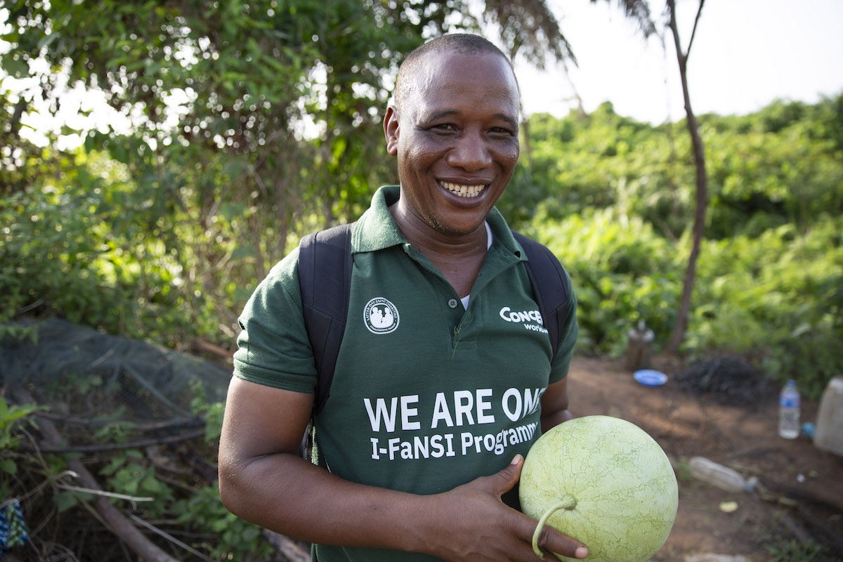 Mohamed Barnes, Concern Field Assistant on IFaNSI programme, holds a watermelon on a farm near Buchanan. (Photo: Kieran McConville/Concern Worldwide)