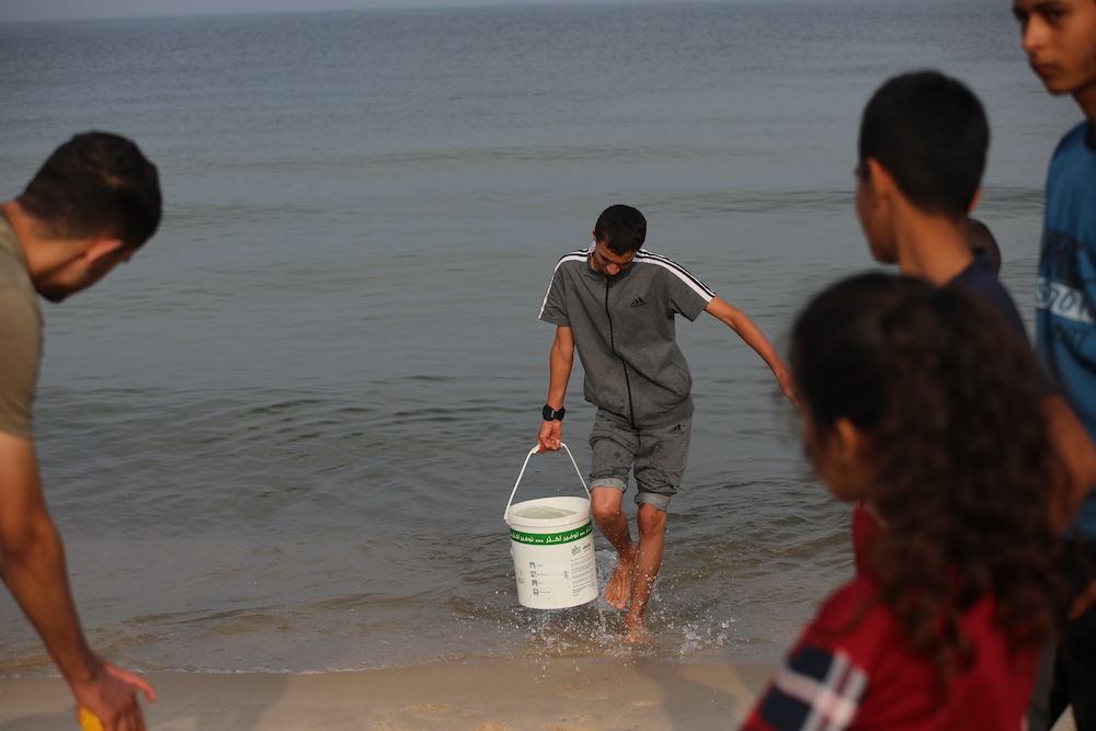 People collect sea water in southern Gaza, to use the water for cooking, cleaning and personal hygiene. Concern Worldwide is supporting our Alliance2015 partner CESVI to deliver life-saving humanitarian aid in Gaza, the response will provide basic emergency needs including: nutrition, safe water, sanitation and hygiene and waste management. (Photo: CESVI)