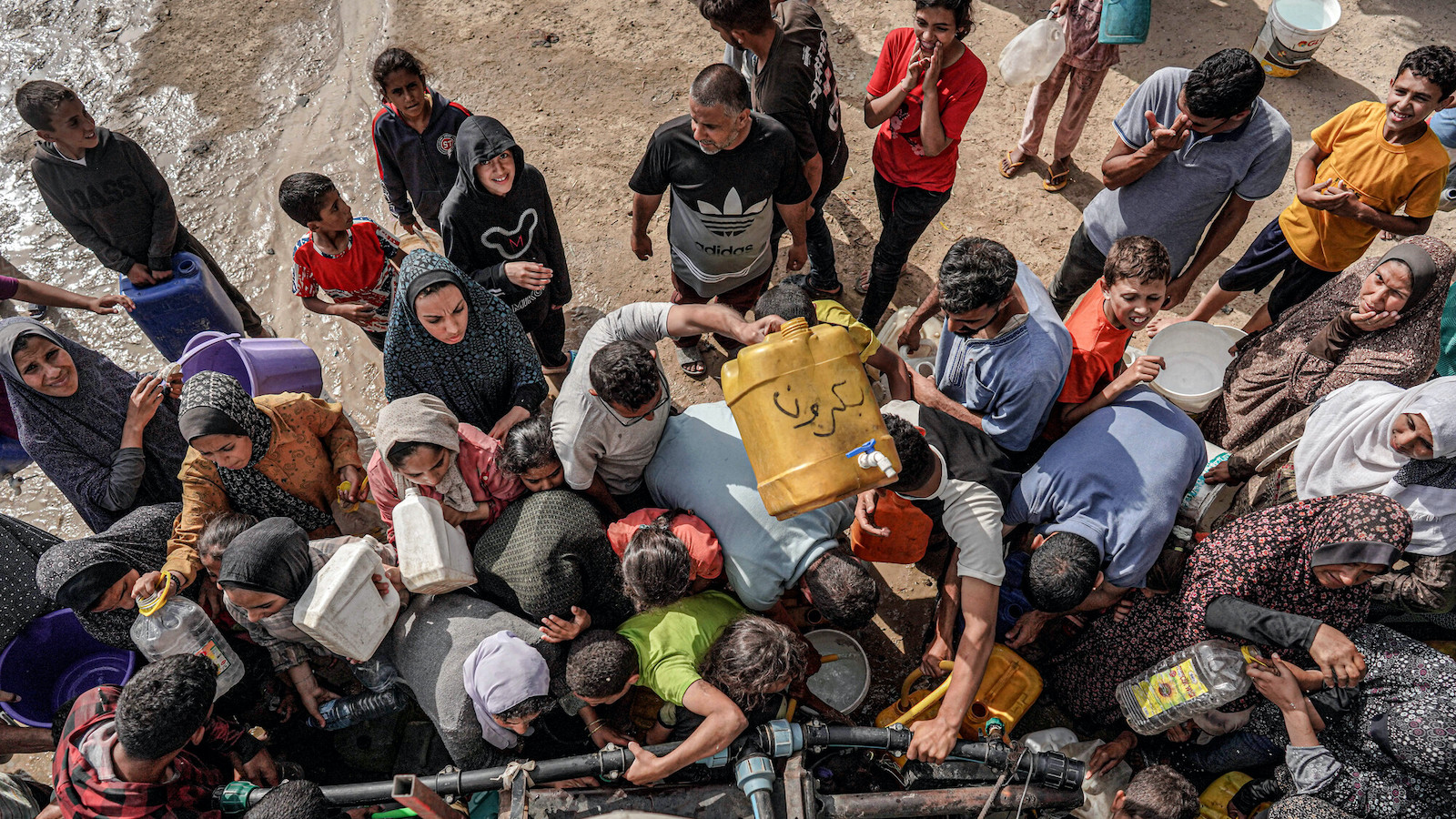People gather with jerrycans and other containers to collect water from a tanker cistern in Deir el-Balah in the central Gaza Strip on April 30, 2024 amid the ongoing conflict in the Palestinian territory. Photo: AFP/Getty Images