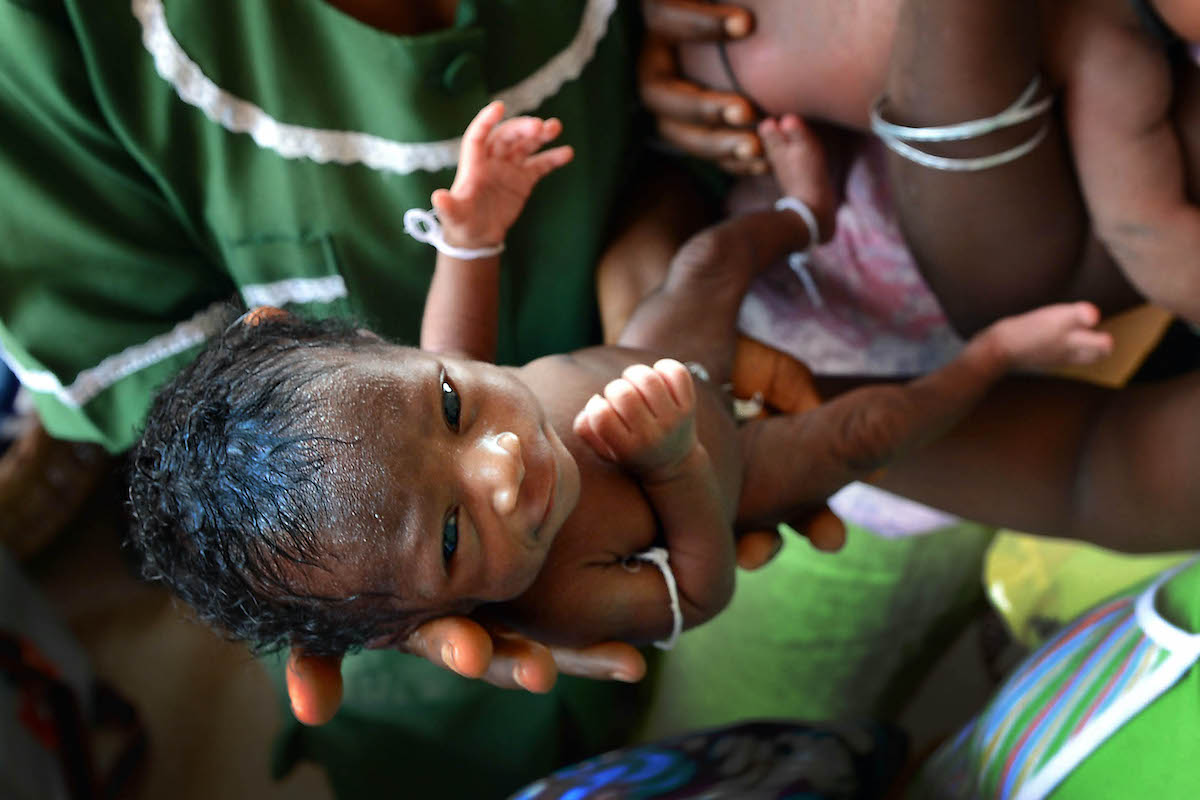 Three-day-old Umaro Monsaray is held by nurses during his health check at the Magburaka Primary Health Clinic, in Tonkolili. Photo: Brenda Fitzsimons/The Irish Times