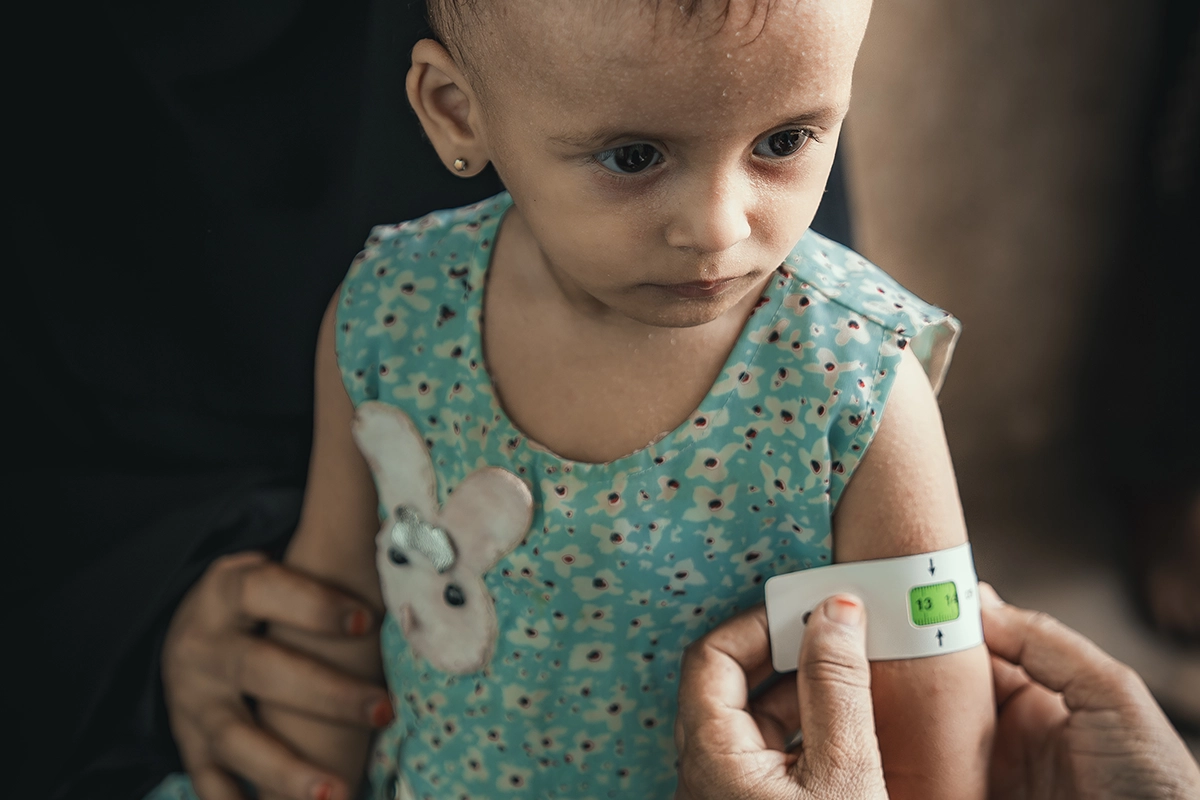 Rima* has her mid-upper-arm circumference (MUAC) measured by a community health volunteer at a Concern-supported clinic in Al-Shaqa'a village, Yemen. (Photo: Ammar Khalaf/Concern Worldwide)