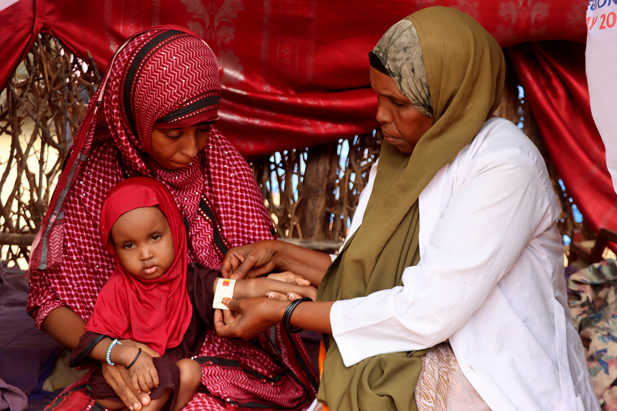 Mother-to-mother support groups play a vital role in enhancing breastfeeding practices and reducing child wasting. At this session in Dollo, Ethiopia, Nurto Mohamud Mohamed learns to monitor her daughter, Anfa's, nutrition with MUAC tape. Photo: Adan Mohamed Afar/Concern Worldwide