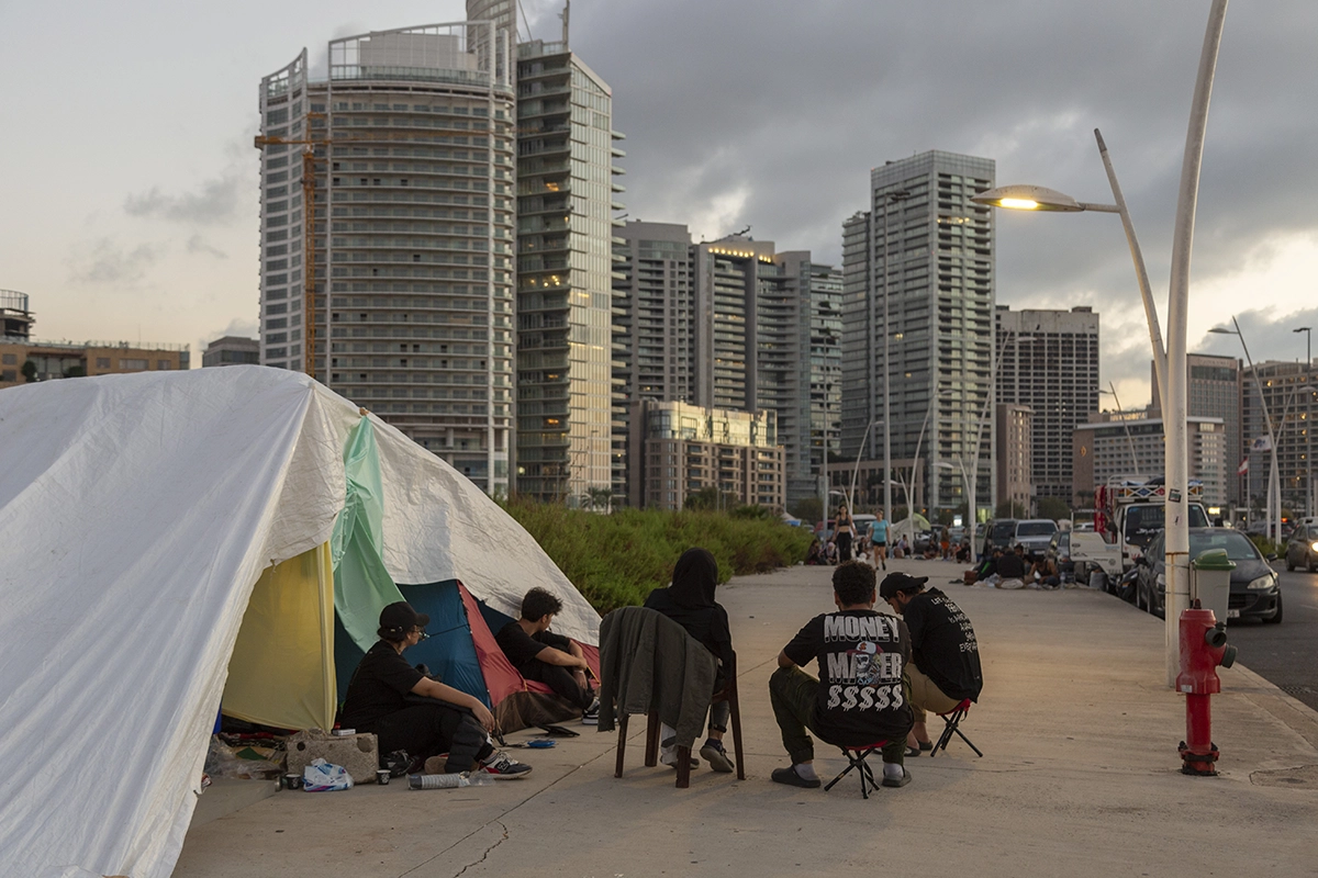 Ahmad* (45), Mazen* (18), Mariana* (37), Hashem* (15) and Leila* (13), sit in front of their tent that they had set up on the sidewalk near the Zeytouna Bay, in Beirut. (Photo: Dalia Khamissy/Concern Worldwide)