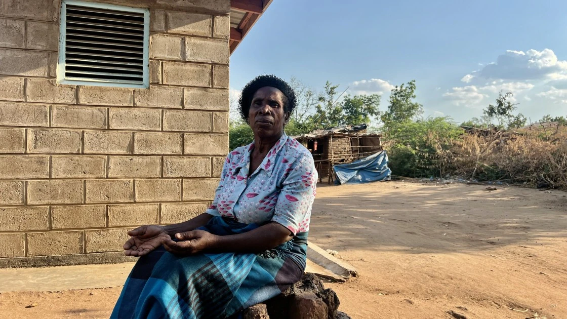 Sige sits in front of a brick home in Bitilinyu Camp, TA Ndamera. Malawi has faced over 20 major climate catastrophes in the last five decades, with events growing in frequency and intensity. (Photo: Lydia Lampiri/Concern Worldwide)