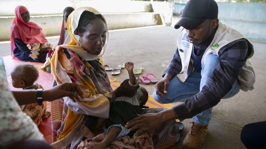Health and Nutrition Coordinator, Hamdoon Abdala, with Zarina* and baby Yaqub* at Ardamata Health Centre in West Darfur. (Photo: Kieran McConville/Concern Worldwide)