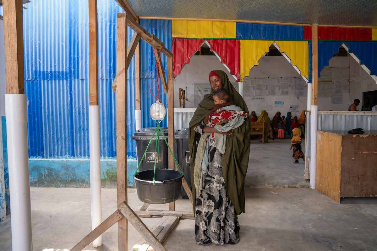 Hoodo* with 8-month-old Mulki* at a Concern-supported clinic near Mogadishu, where they traveled after attacks on their home village killed Hoodo's husband. “I knew my baby was sick, but I did not know where to take her because I feared being given medication I could not afford. Fortunately, the health workers from Concern visited the camp, saw my child, tested her, and gave her the RUTF and some medication to help with her symptoms.” Photo: Eugene Ikua/Concern Worldwide