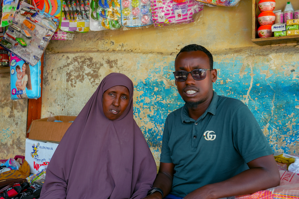 Concern Somalia Program Supervisor Abshir Osman Mohamud with Mako at her shop. (Photo: Adnan/Mohamed/Concern Worldwide)