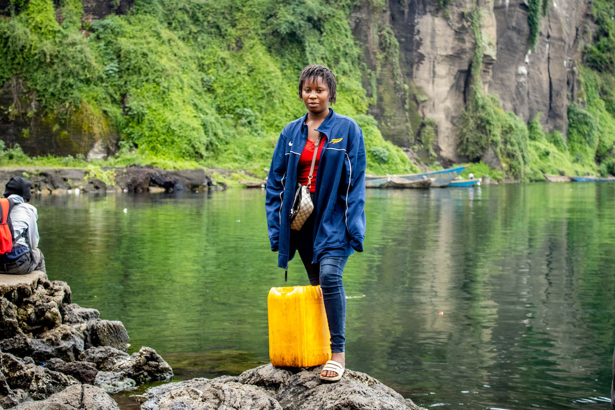 Aminatou* draws water directly from Lake Kivu and chlorinates the water with the support of Concern, FCDO funding through the SAFER program. Photo: Concern Worldwide